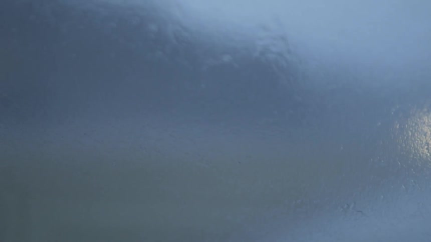 A vehicle's windshield wipers swipe back and forth as it drives
