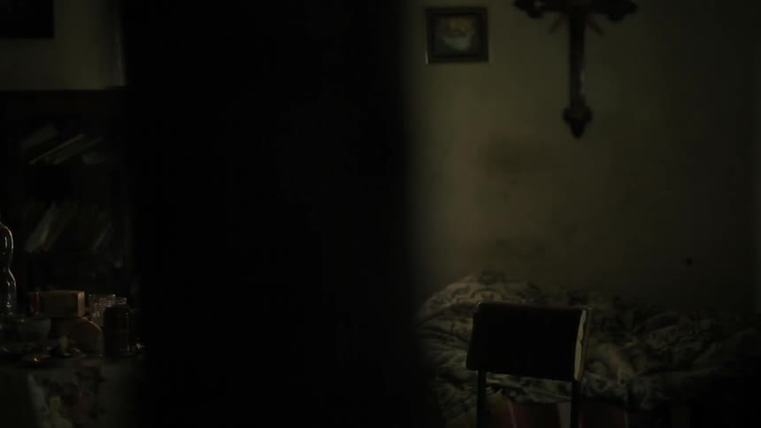 A messed up bed in a dark room