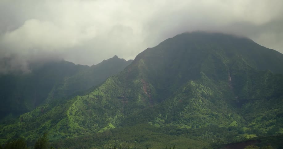 Clouds drift over island mountains during the day