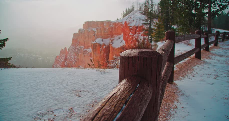 Snow falls near a red rock canyon