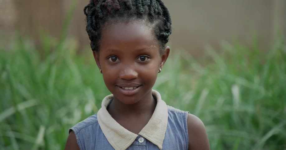 A girl stands outside smiling and looking around
