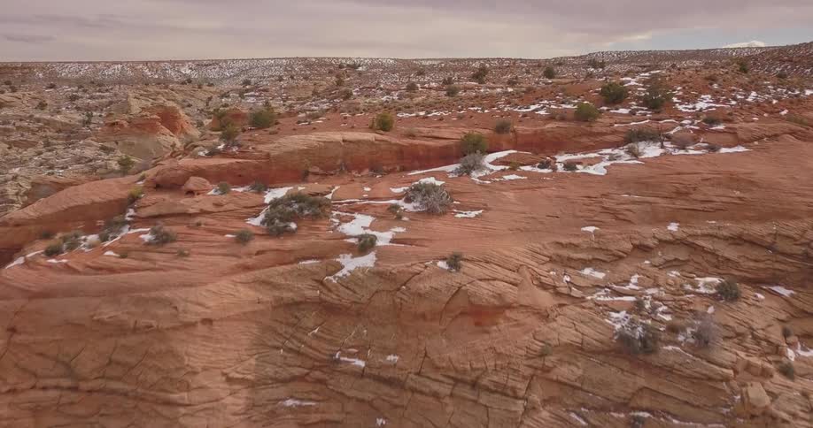 Snow sparsely covers the hilly landscape