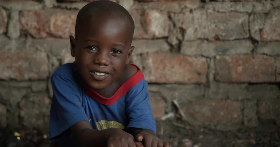 Young child lays on his tummy as he smiles and talks