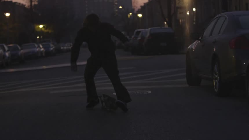 A skateboarder jumps in a parking lot