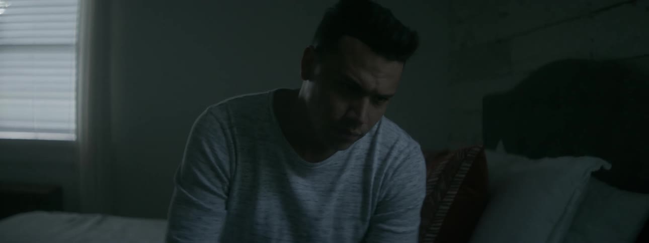 Man looks worried while sitting on a bed