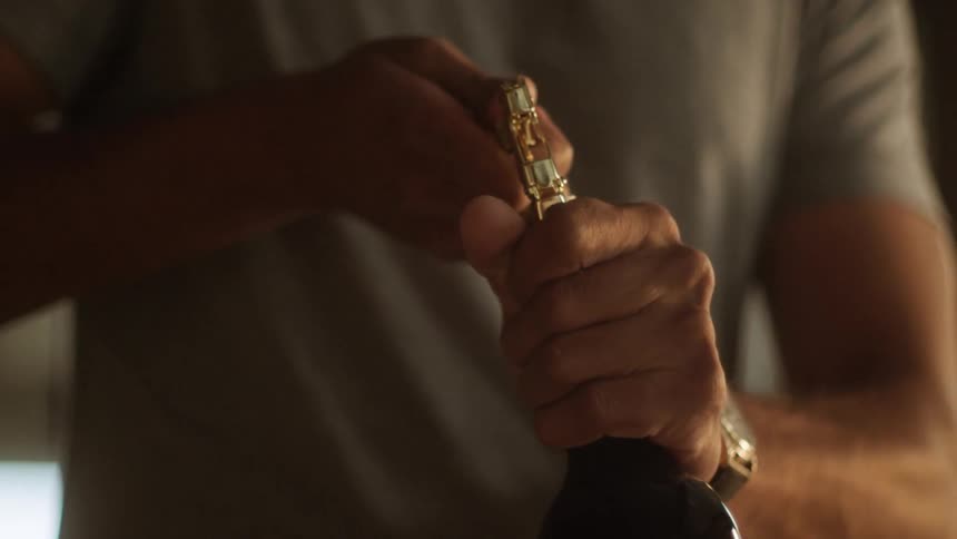 A man uncorks a bottle