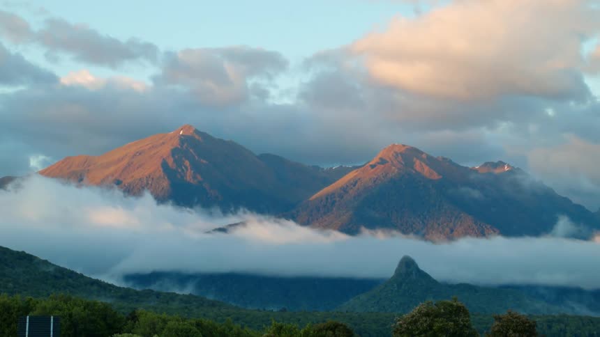 Clouds pass above and between mountains