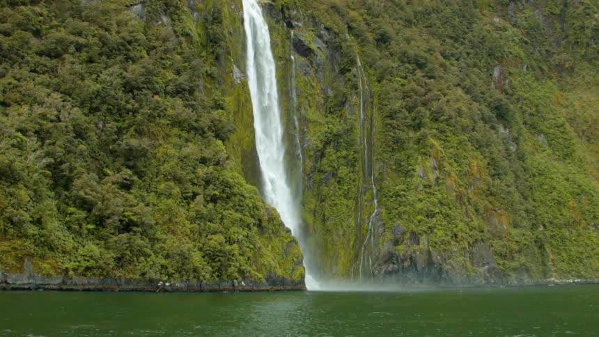 Water falls down a cliff into a lake