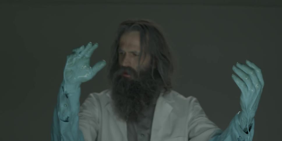 A man pulls his hands out of blue liquid