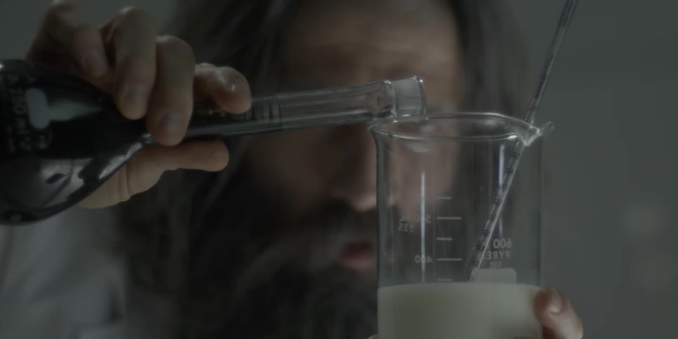 A scientist mixes two liquids in beakers