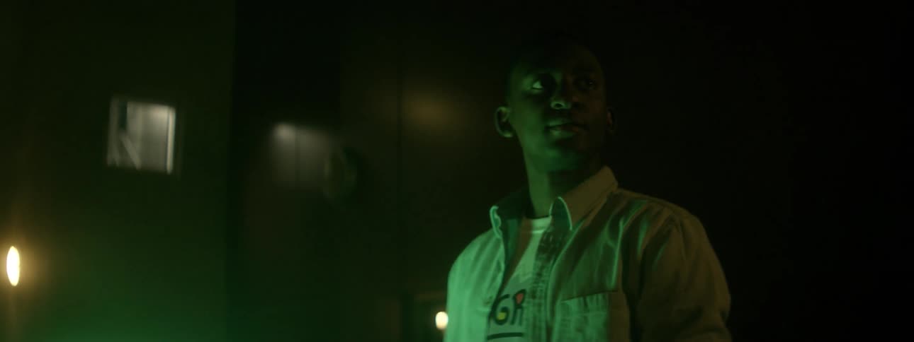 A man stands outside with a large green light