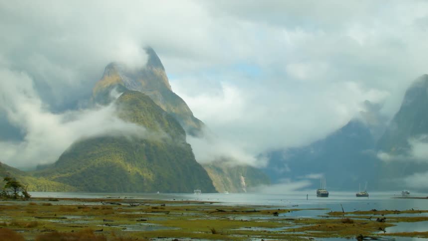 Clouds hover near tall mountains
