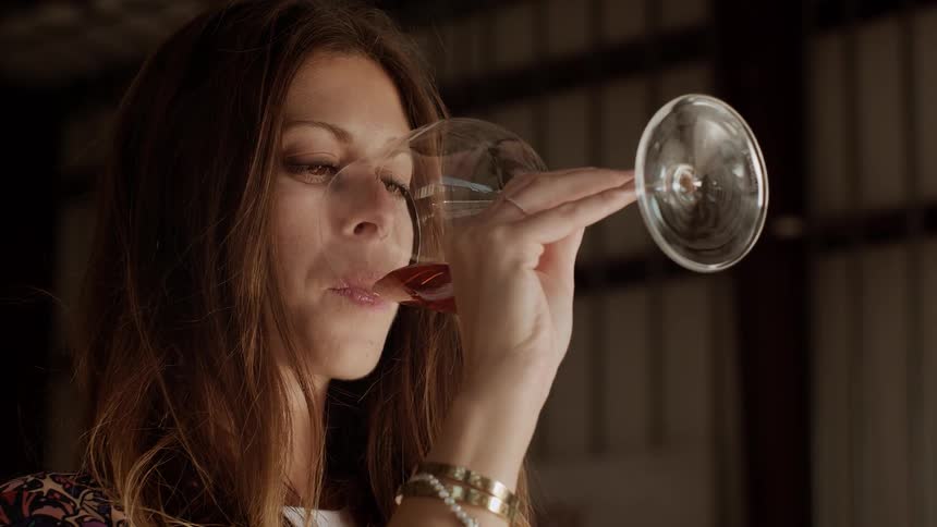 A woman takes a drink of wine
