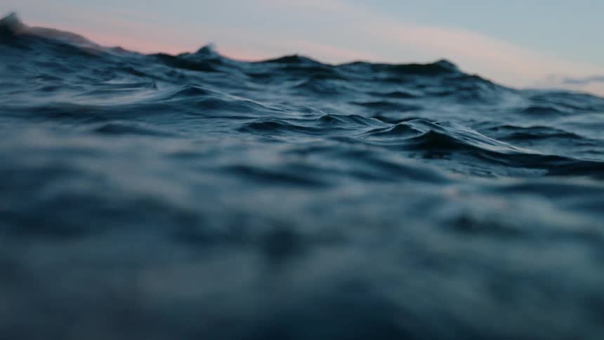 The tide undulates and rolls in the ocean at dusk