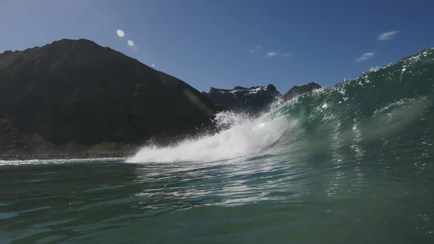 A large wave crests as it approaches the shore