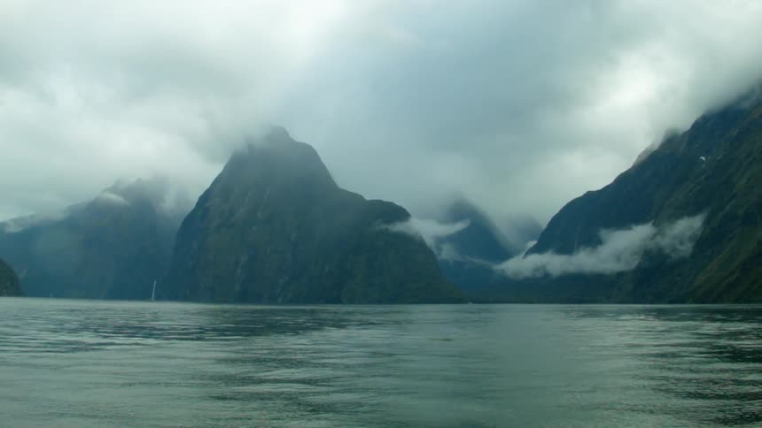 Clouds hang low over a mountainous coastline