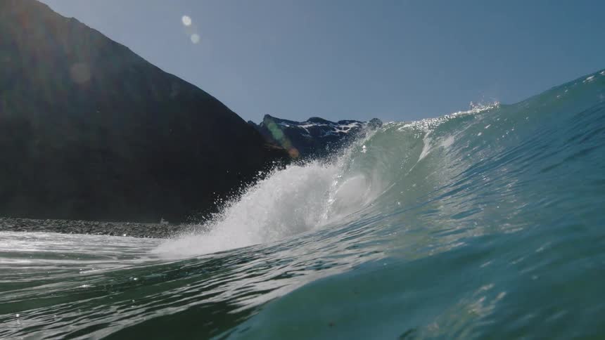 A wave crests and crashes as it rolls toward the shore