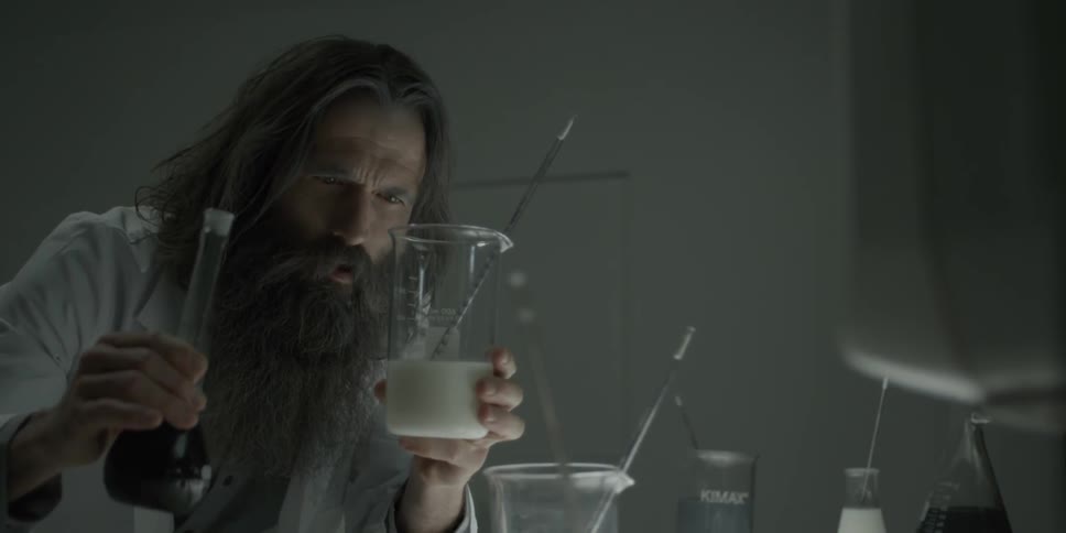 A man mixes two liquids into one beaker
