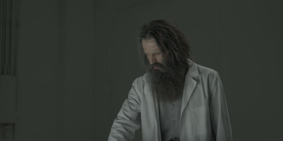 A scientists is placing his hand into something below him