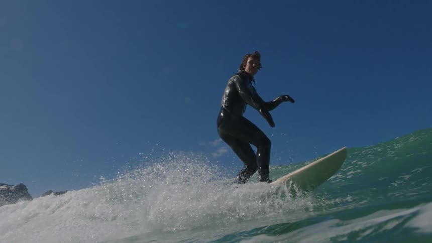A surfer rides a tall wave