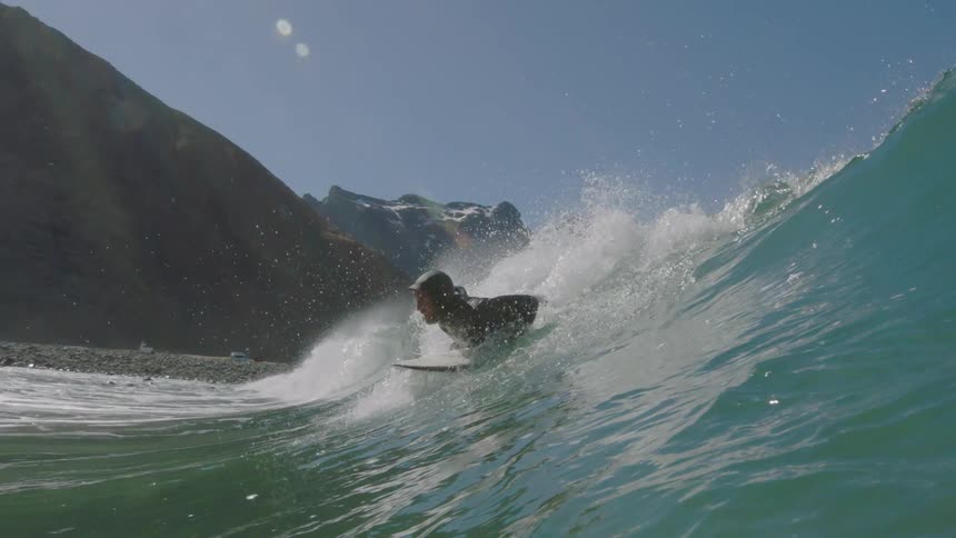 A man rides a tall blue wave