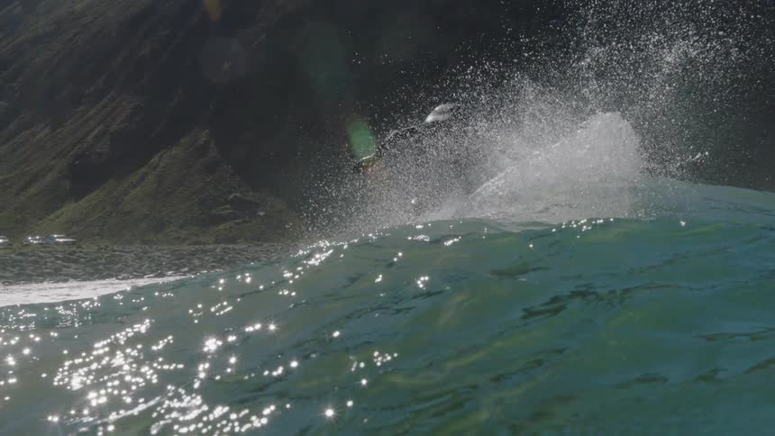 A surfer cuts across a wave he is riding on