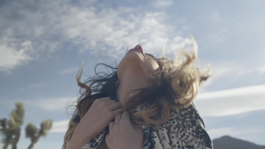 Woman tilts her head back towards sky