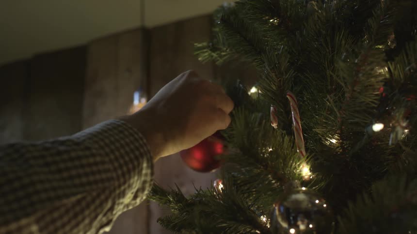 Person decorating a christmas tree