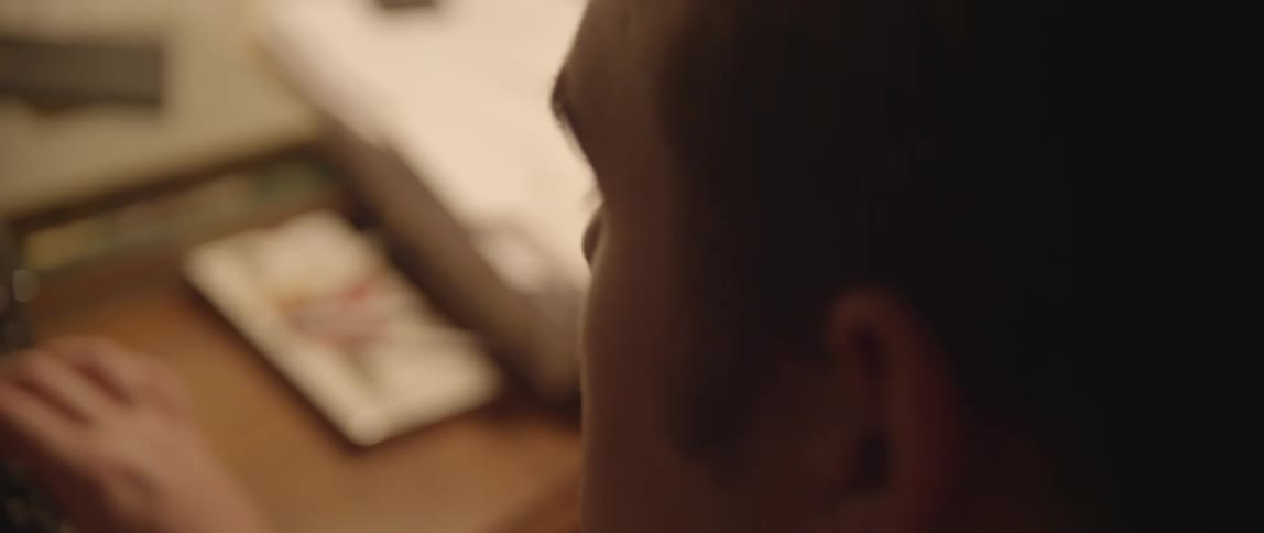Man looking over some items on a desk