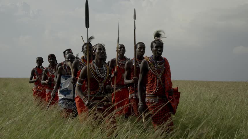 Maasai in costume performing a dance with spears