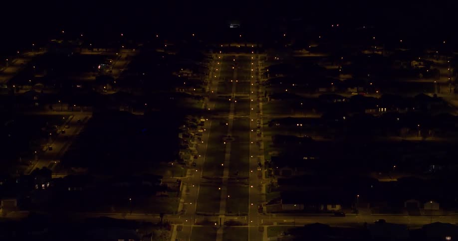 Lamp posts illuminate the road at night