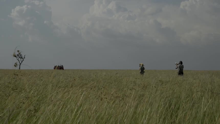 Photographers take pictures of a group of natives marching