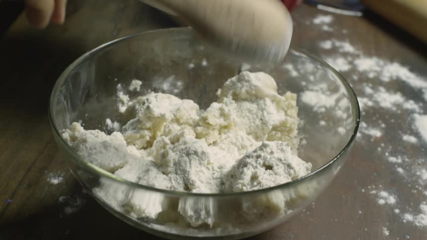 Flour is added to a bowl of ingredients