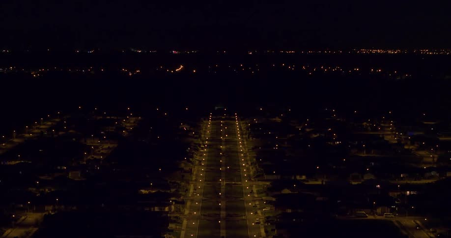Lamp posts illuminate the road at night