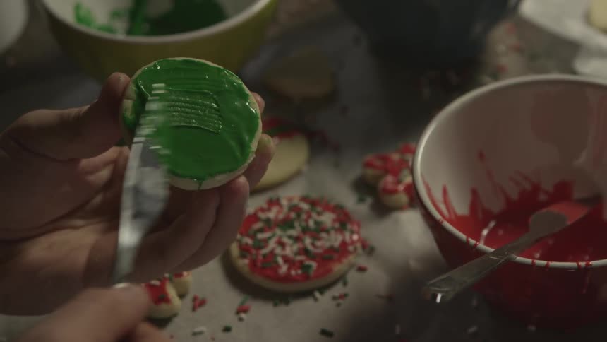A woman is decorating cookies