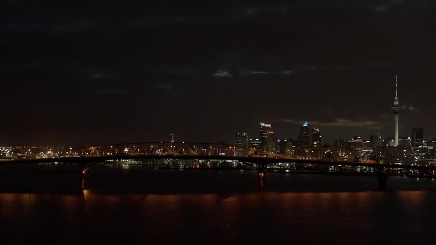 Vehicles travel over a bridge at night