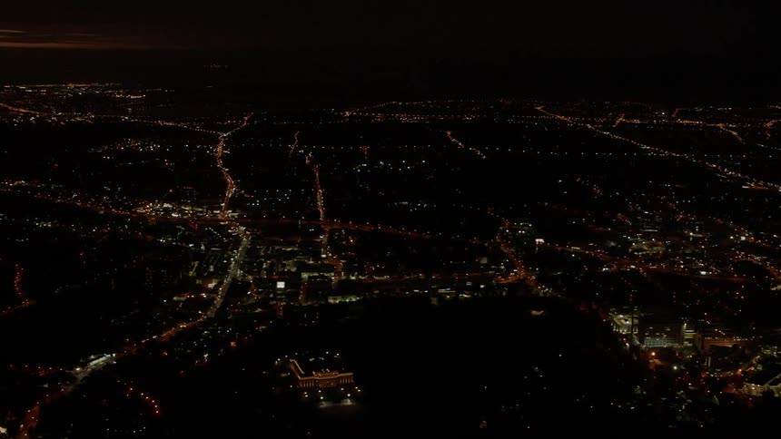 Lights illuminate buildings and streets in a city at night