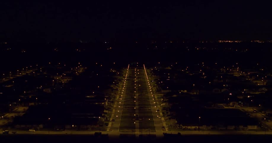 Lamp posts illuminate the road at night