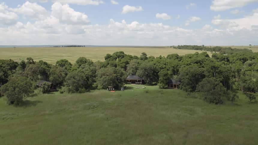 Trees and structures sparsely cover the open field