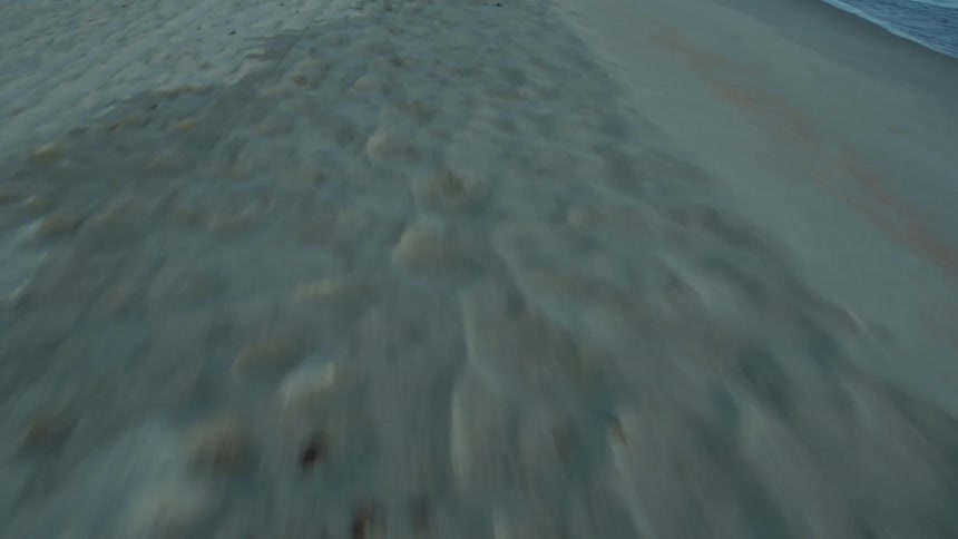 Waves crashing on an empty beach on a sunny day