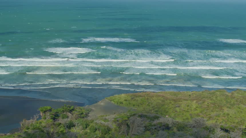 Waves are rolling toward the beach on a sunny day