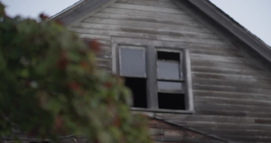 An old residential building sits with its windows ajar