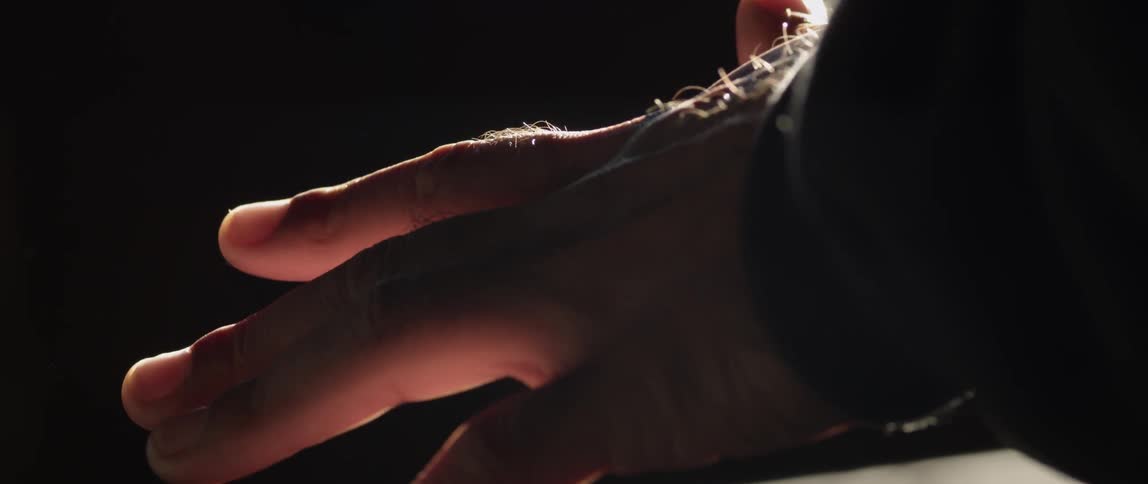A person turns their hands in the light