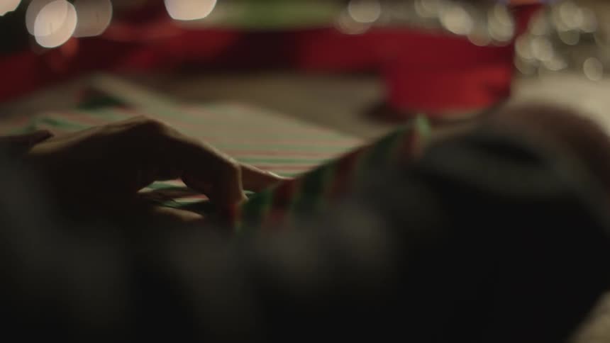 A person wraps a christmas present