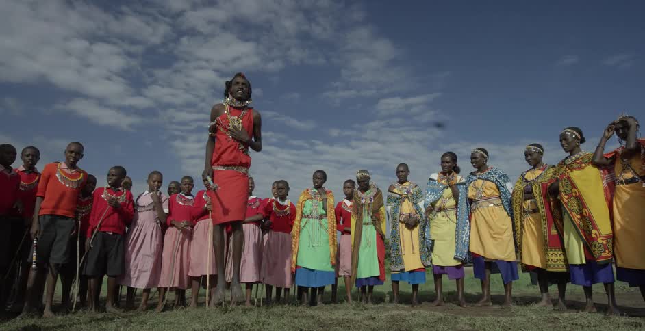 Maasai people stand in a circle and perform during the day