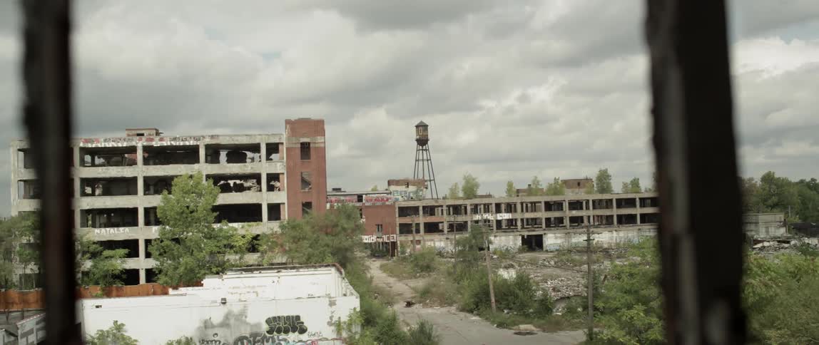 Clouds float over rundown city buildings