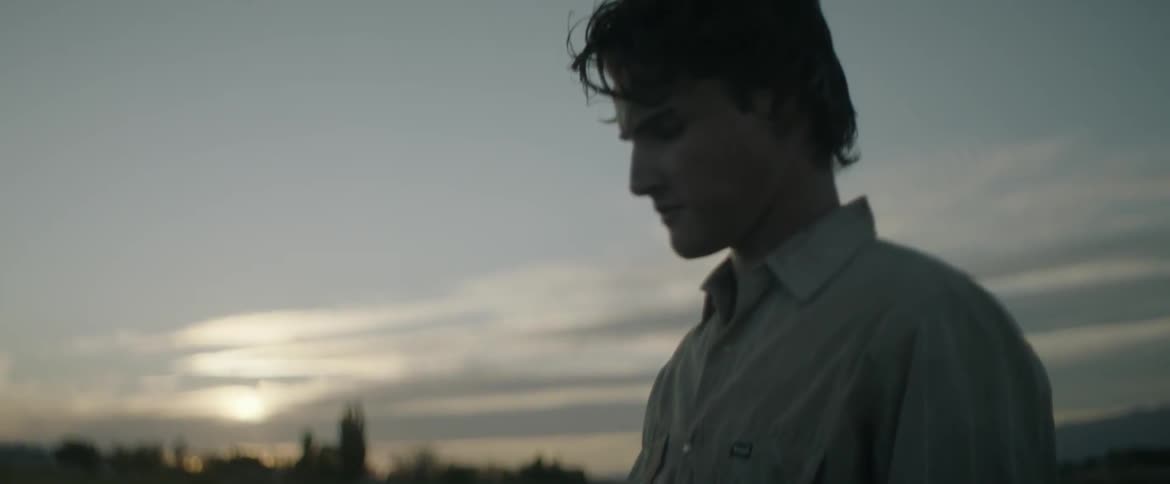 A man stands outside at dusk