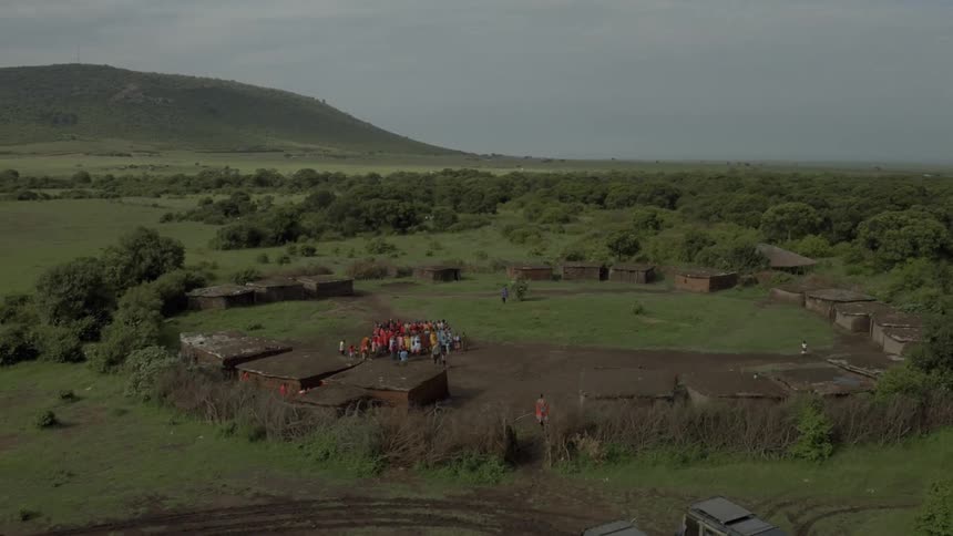 A group of school children gather in a field