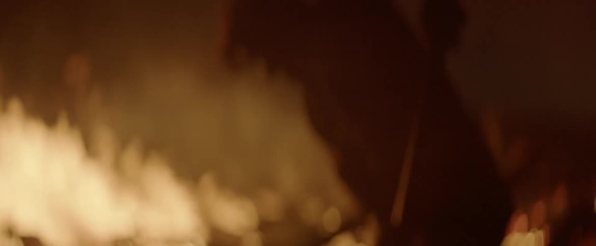 A man frantically attempts to extinguish a fire