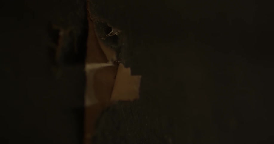 Brick is stacked outside of a tattered doorway